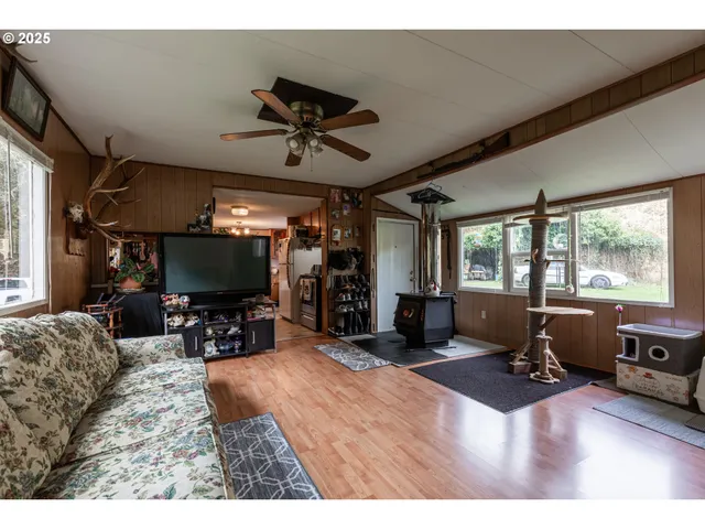 a living room with furniture a flat screen tv and a large window