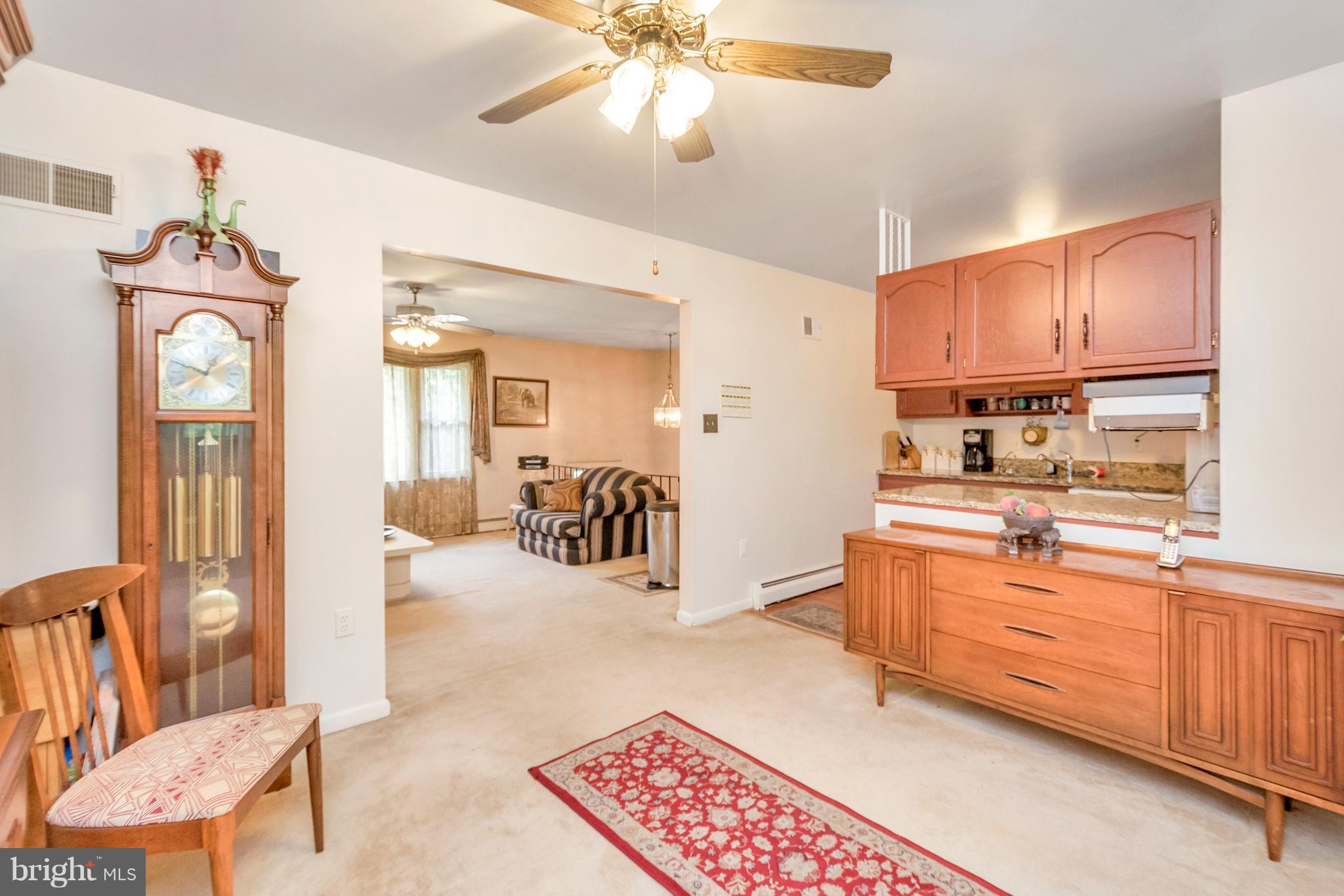 4717 Kilbane Road Woodbridge, VA 22193 - Photo 8 of 29 a kitchen with stainless steel appliances kitchen island granite countertop a refrigerator a stove a sink a dining table and chairs with wooden floor