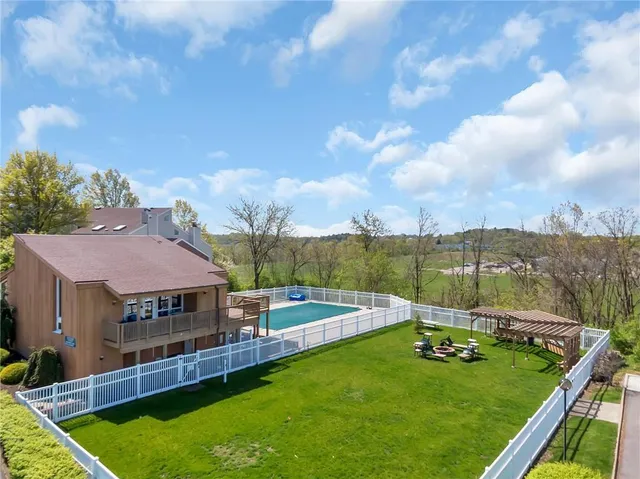 an aerial view of a house with a garden and lake view