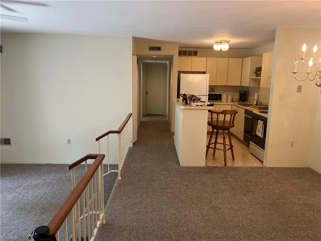 a view of a kitchen with kitchen island wooden floor and electronic appliances