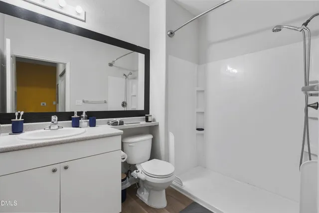 a bathroom with a sink toilet vanity and shower