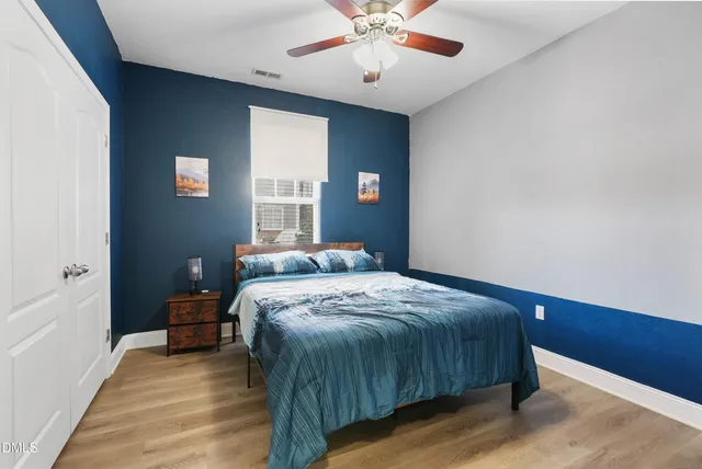 a bedroom with a large bed and a chandelier