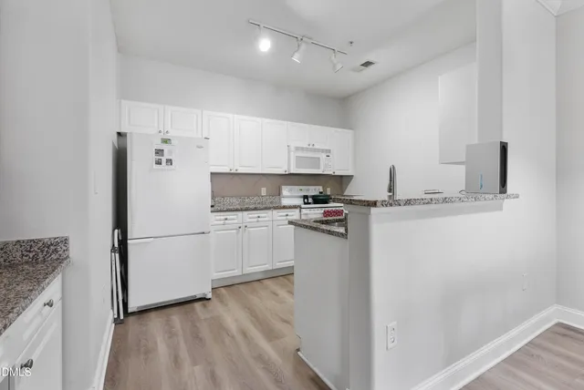 a kitchen with stainless steel appliances a refrigerator sink and microwave
