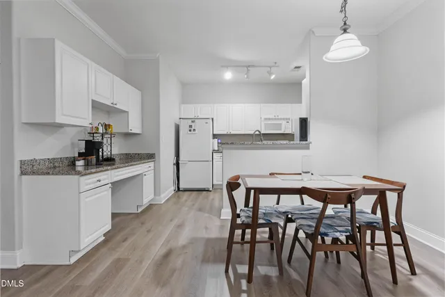 a kitchen with stainless steel appliances kitchen island granite countertop a dining table chairs and sink
