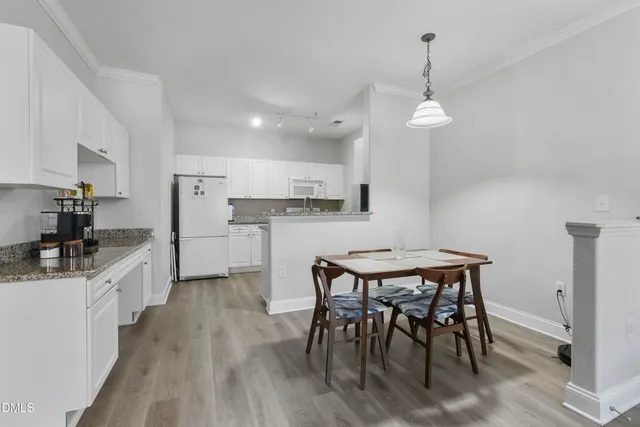 a kitchen with stainless steel appliances a dining table chairs stove and refrigerator