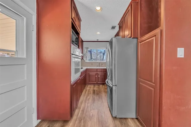 a view of a hallway with wooden floor and staircase