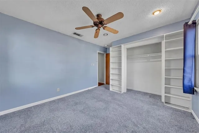 a view of an empty room with a ceiling fan