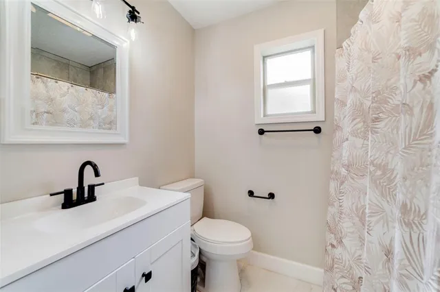 a bathroom with a toilet a sink and mirror