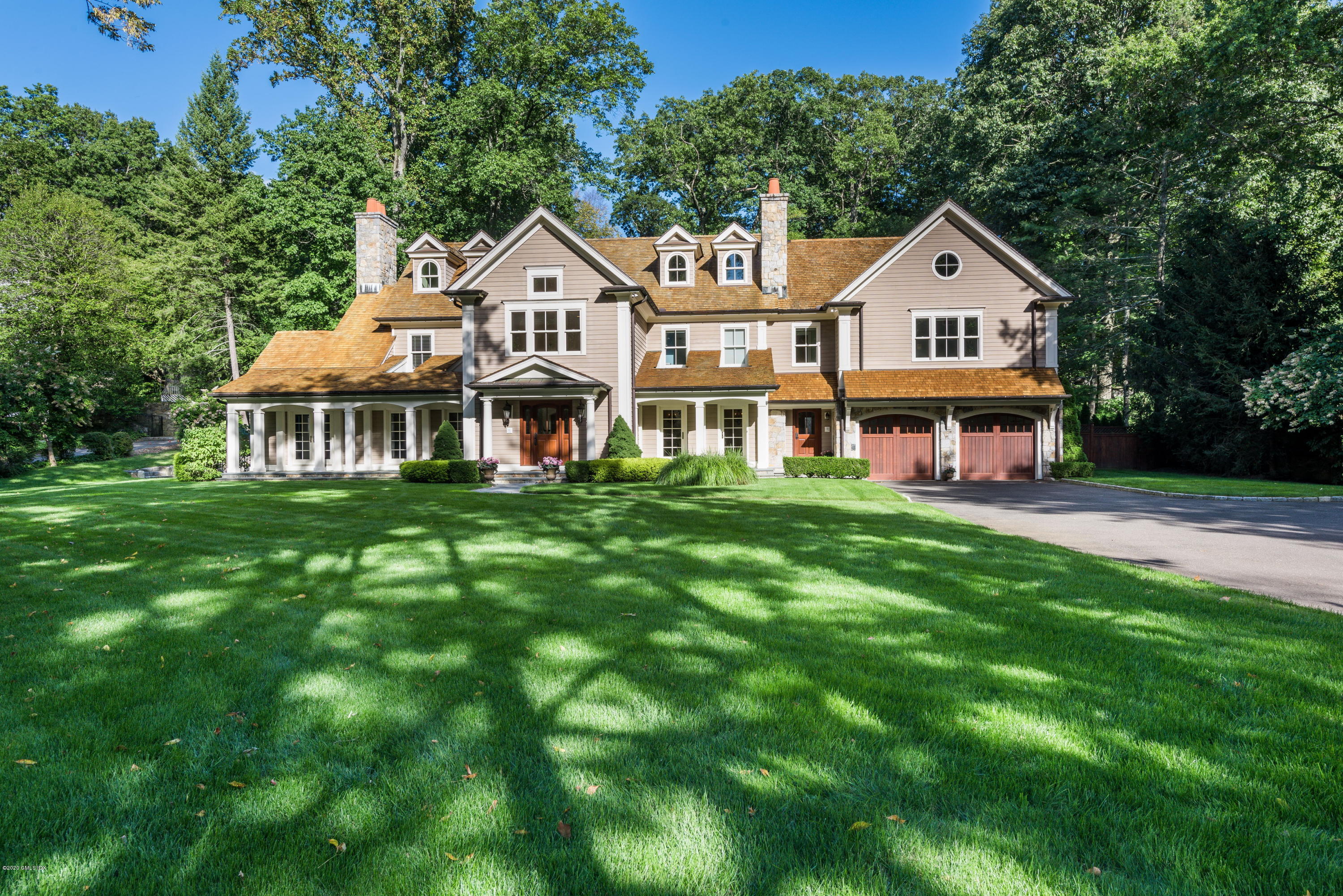 a front view of a residential houses with yard and green space