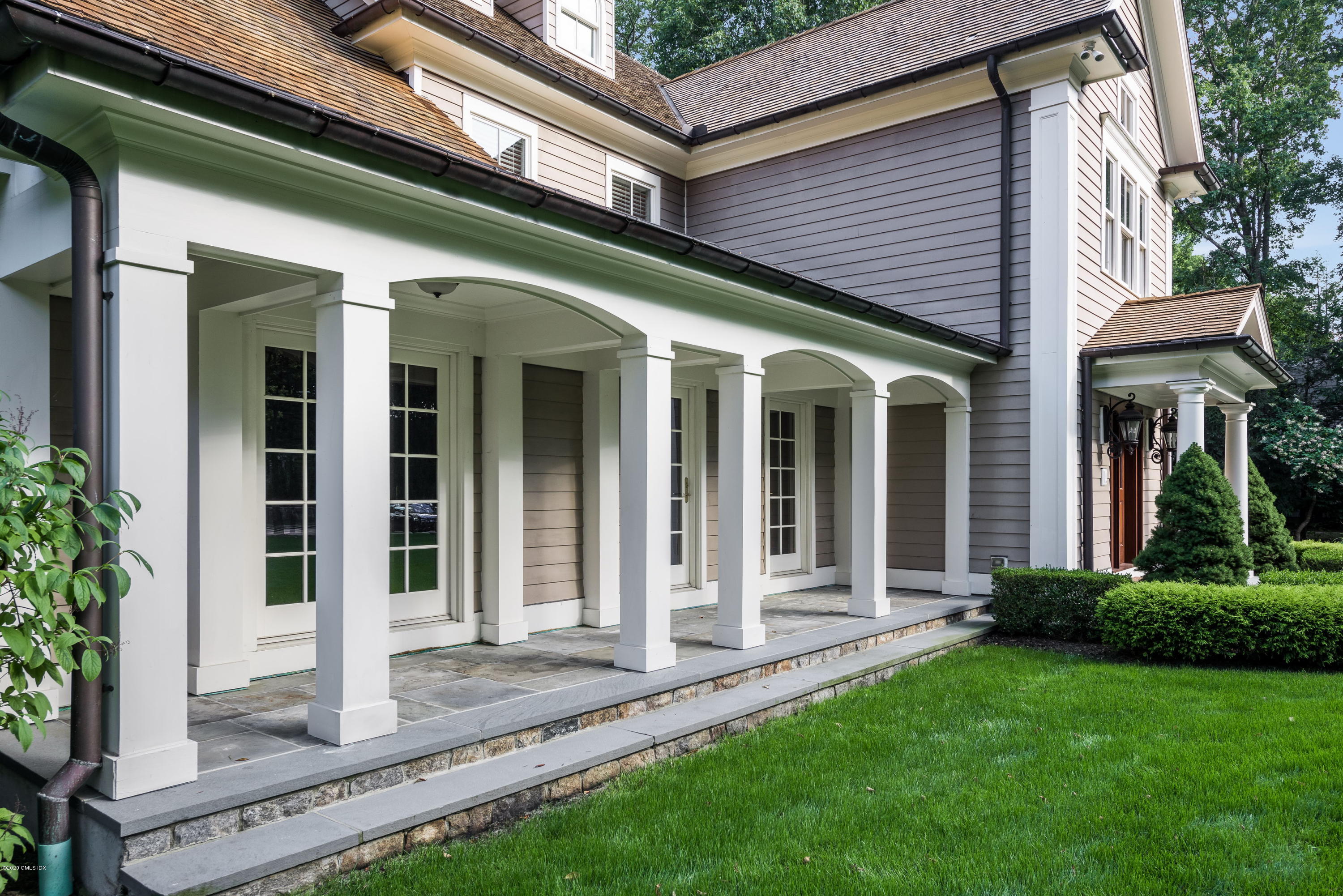 53 Hillside Road Greenwich, CT 06830 - Photo 3 of 31 a view of a house with brick walls and a yard with plants