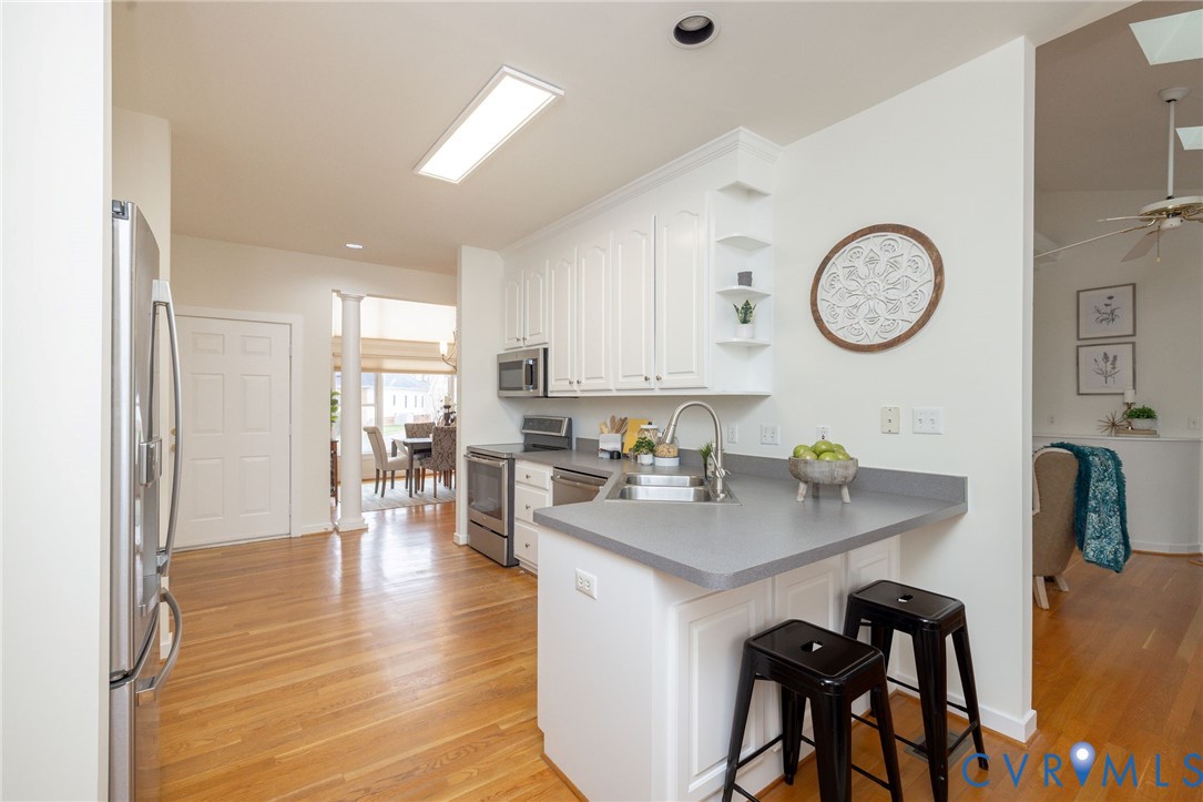 5713 Promontory Place Midlothian, VA 23112 - Photo 13 of 39 a kitchen with a table chairs and a stove top oven with wooden floor