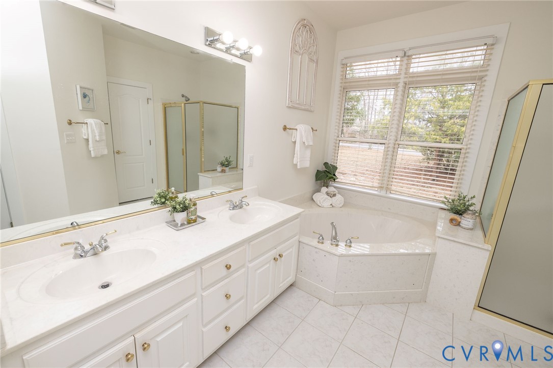 5713 Promontory Place Midlothian, VA 23112 - Photo 20 of 39 a bathroom with a double vanity sink large mirror and a bathtub