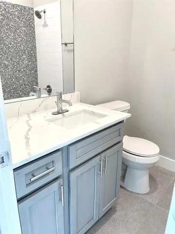 a bathroom with a sink a toilet and mirror