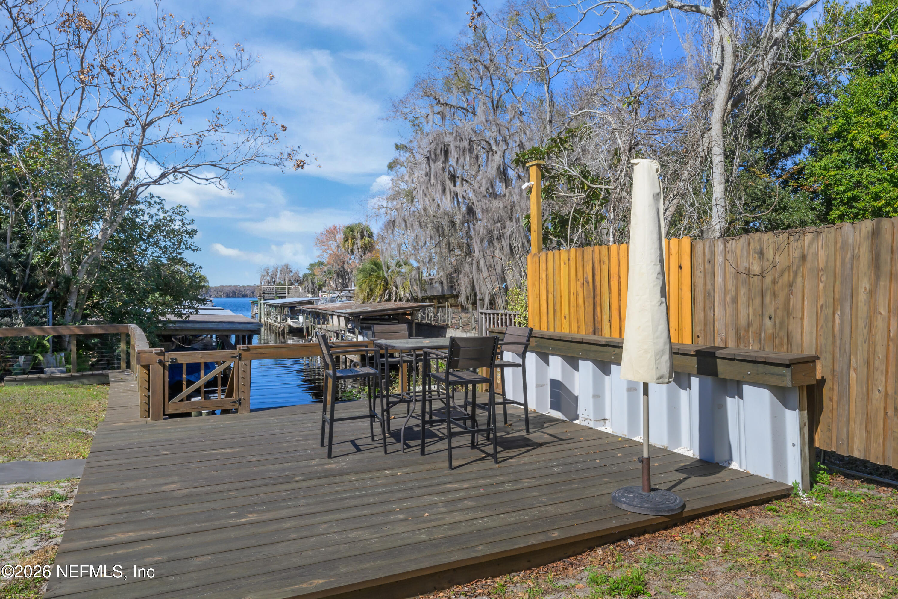 253 Hess Road Crescent City, FL 32112 - Photo 8 of 38 a view of a patio with table and chairs with wooden floor and fence