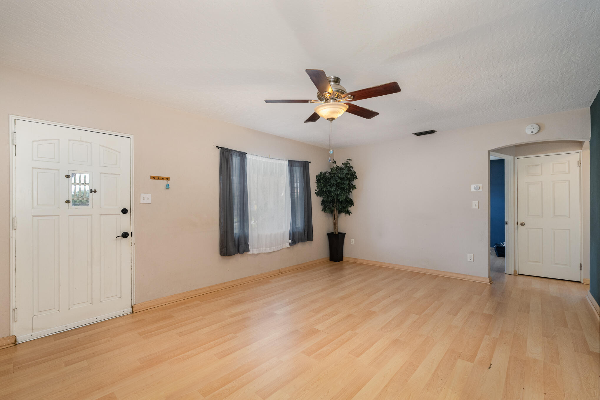 1908 Glendon Drive Melbourne, FL 32901 - Photo 5 of 26 a view of a big room with wooden floor and a chandelier fan