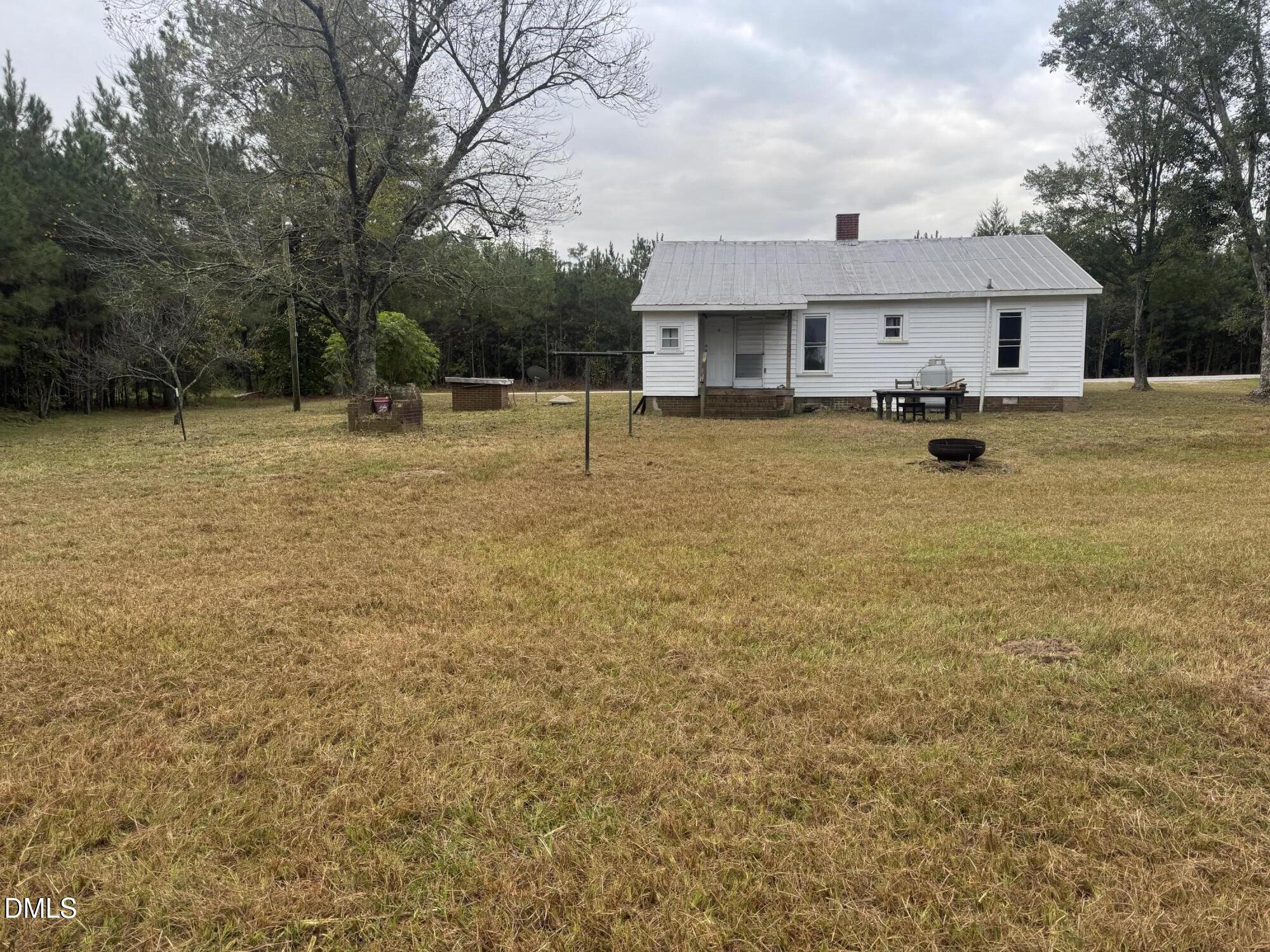 11220 Highway 27 Lillington, NC 27546 - Photo 2 of 2 a front view of house with yard swimming pool and trees in the background