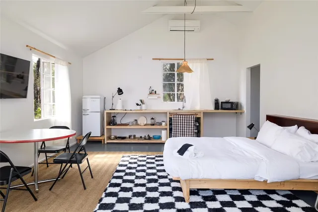 a kitchen with stainless steel appliances a sink a stove a window and a dining table