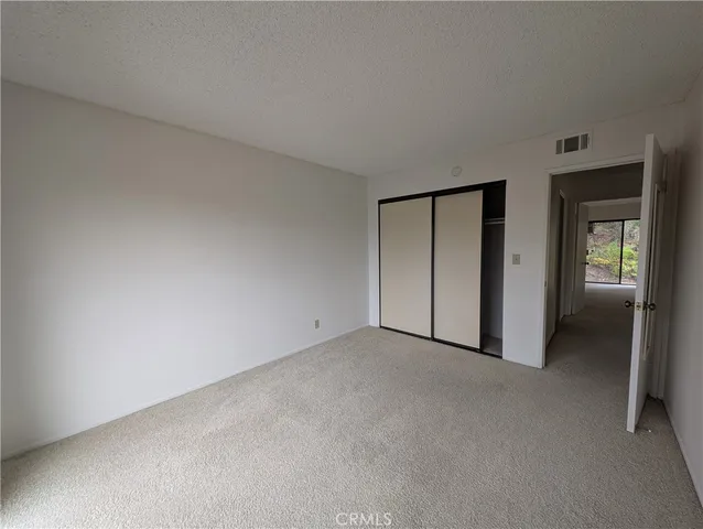 an empty room with closet and mirror