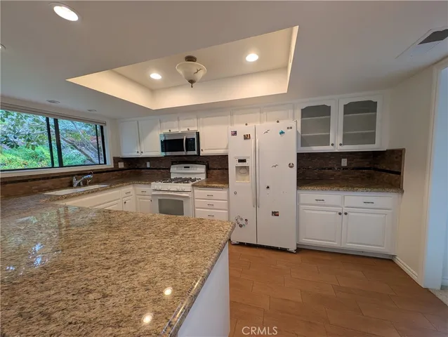 a large kitchen with stainless steel appliances granite countertop a stove a sink and a microwave