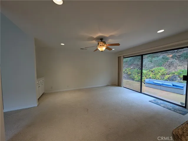 a view of a livingroom with a ceiling fan and window