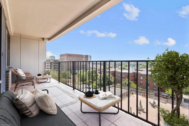 a balcony with furniture and a potted plant