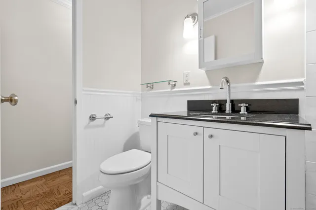 a bathroom with a granite countertop toilet sink and mirror