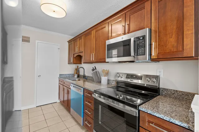 a kitchen with stainless steel appliances granite countertop a stove microwave and sink