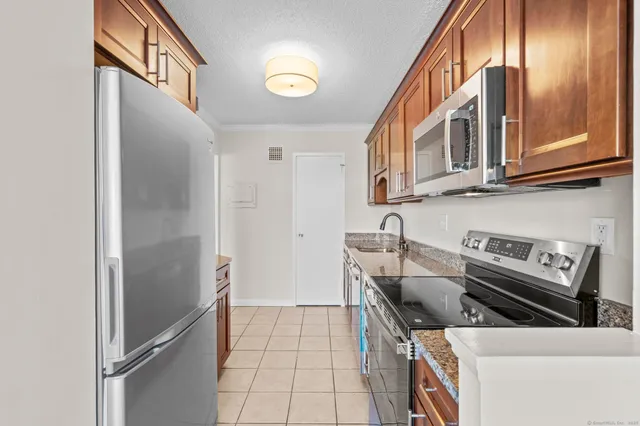 a kitchen with stainless steel appliances granite countertop a refrigerator and a stove