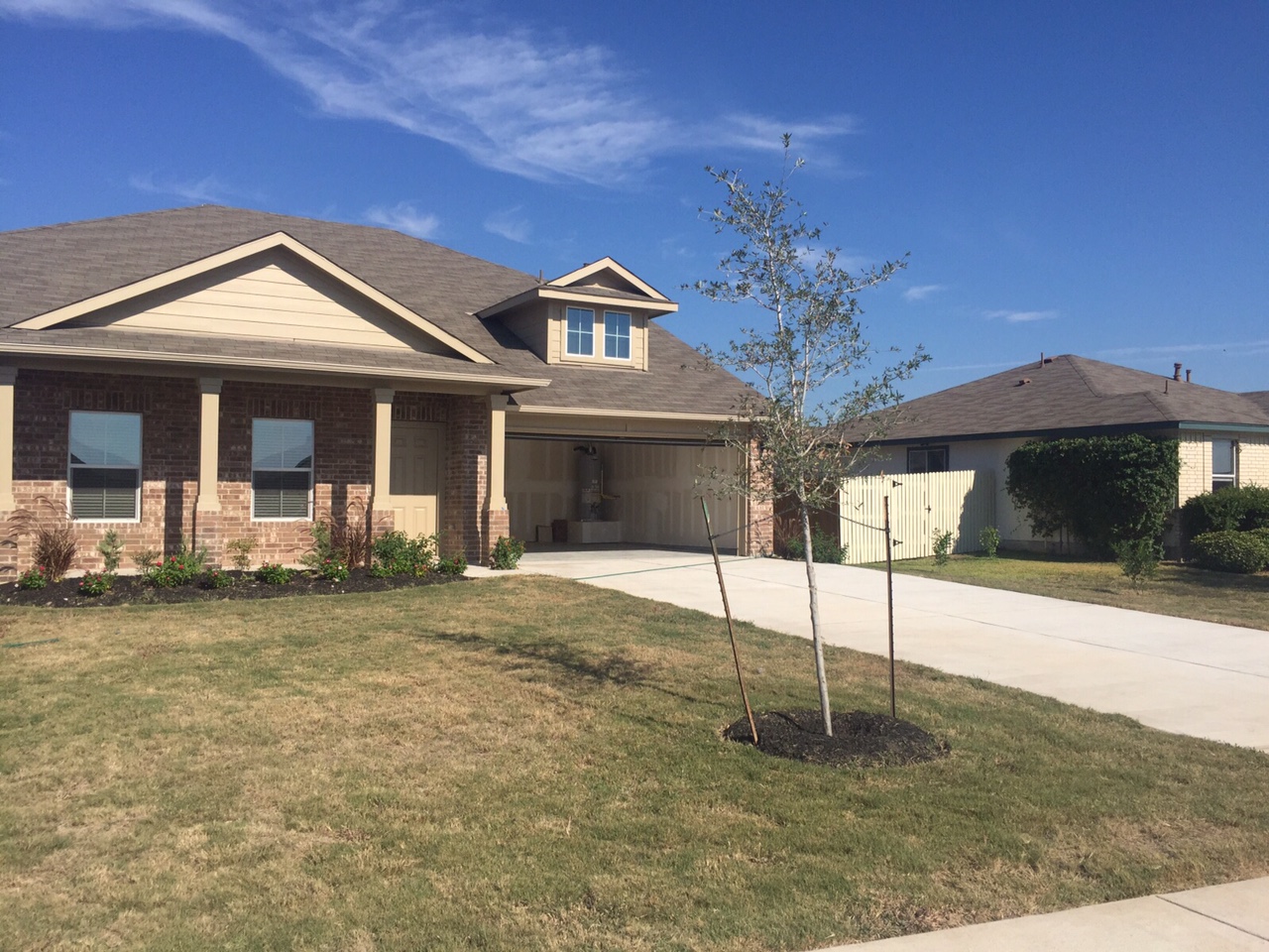 384 Discovery Kyle, TX 78640 - Photo 1 of 18 View of front facade with concrete driveway, a garage, brick siding, and covered porch