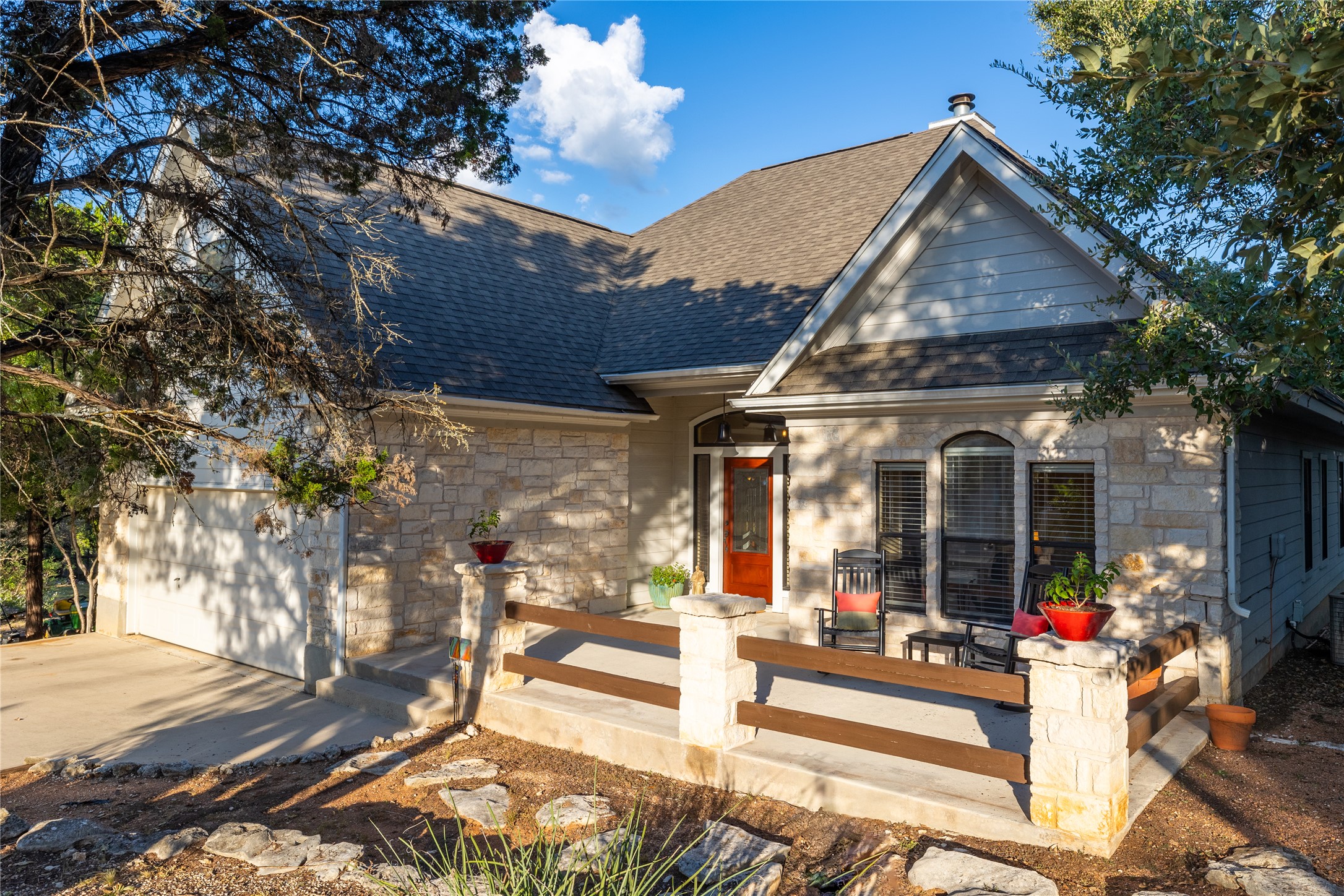 14 Springwood Wimberley, TX 78676 - Photo 1 of 1 View of front of property featuring stone siding, a shingled roof, a garage, and concrete driveway