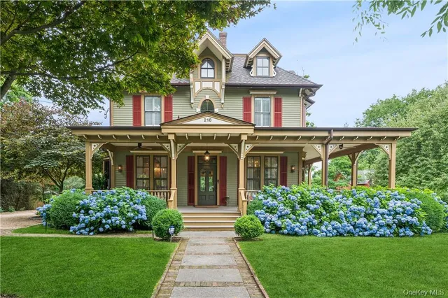 a front view of a house with a yard and potted plants