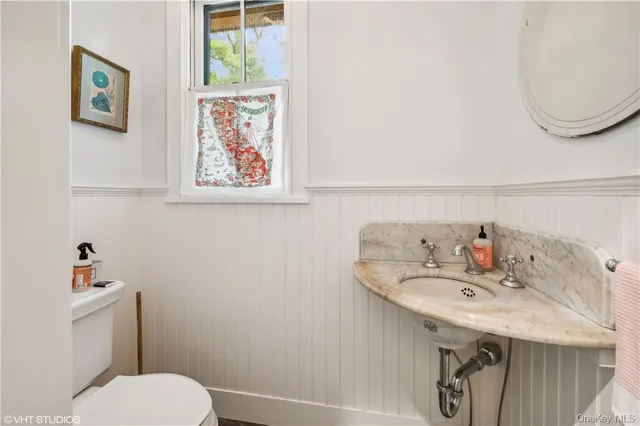 a bathroom with a sink mirror and toilet