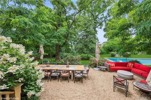an outdoor sitting area with furniture and garden view