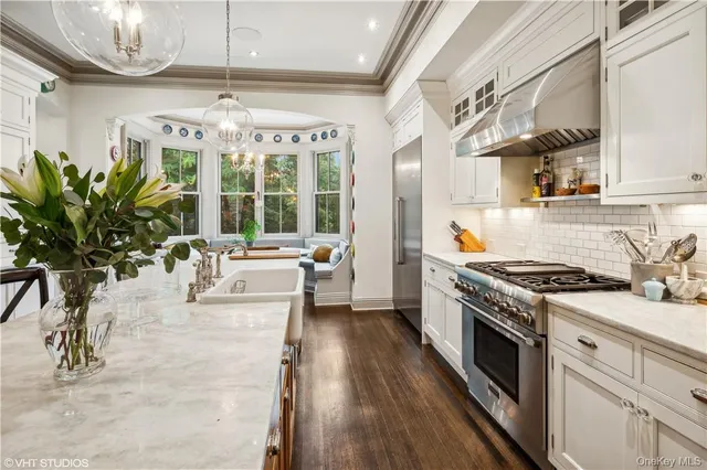a kitchen with stove a chandelier and wooden floor