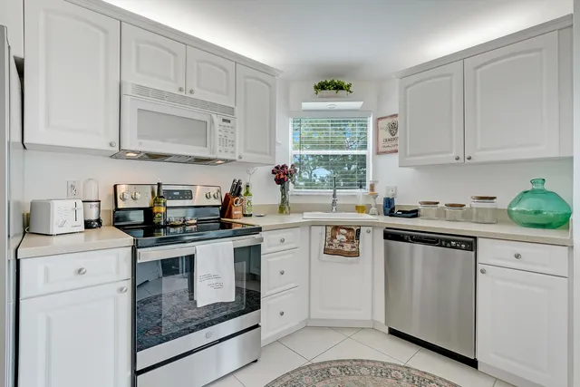 a kitchen with white cabinets and white appliances