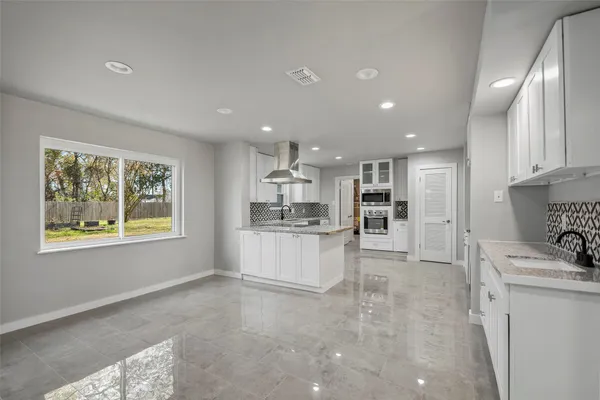 a view of kitchen with refrigerator and windows