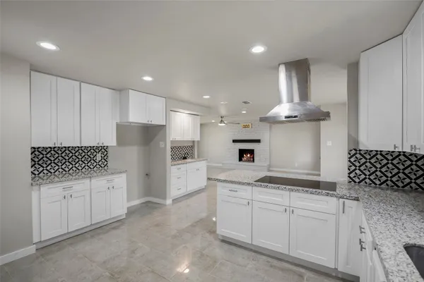 a kitchen with stainless steel appliances kitchen island granite countertop a refrigerator and cabinets