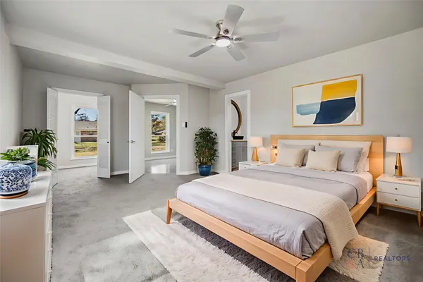 a spacious bedroom with a bed and ceiling fan