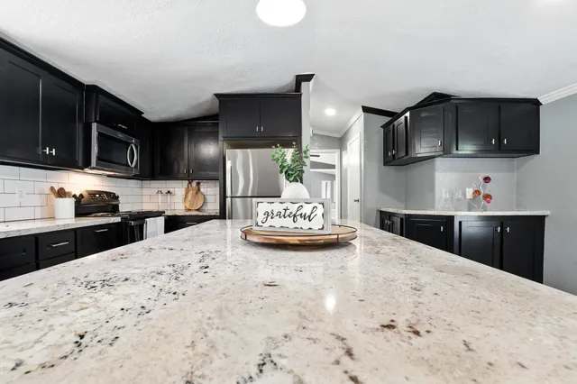 a kitchen with stainless steel appliances kitchen island granite countertop a stove sink and microwave