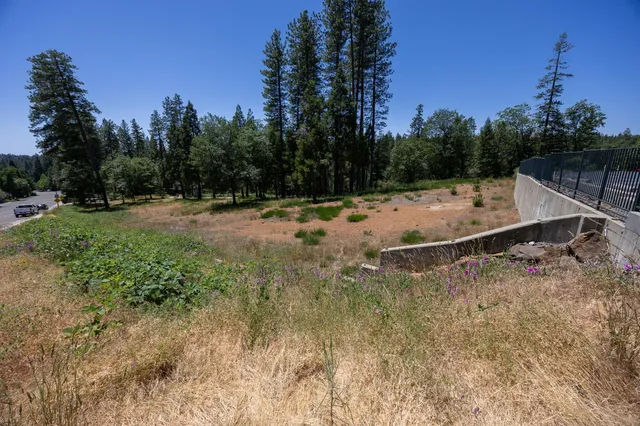 an aerial view of residential house with outdoor space and trees all around