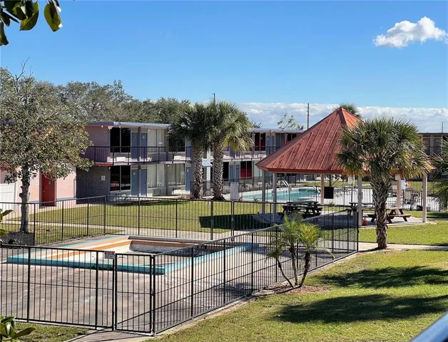 a view of backyard with swimming pool and seating space