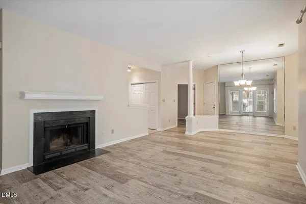 a view of empty room with wooden floor and fireplace