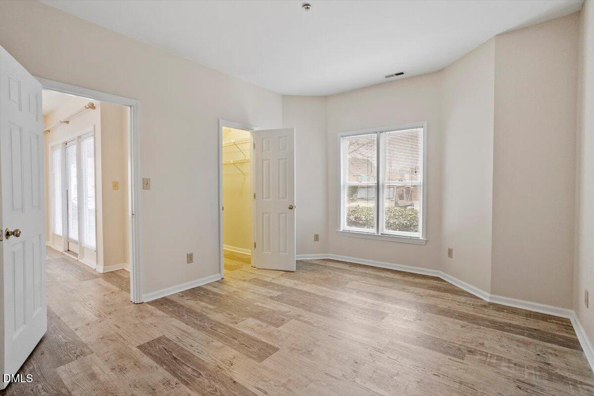 1001 Brighthurst Drive, Unit 106 Raleigh, NC 27605 - Photo 14 of 23 a view of an empty room with wooden floor and a window