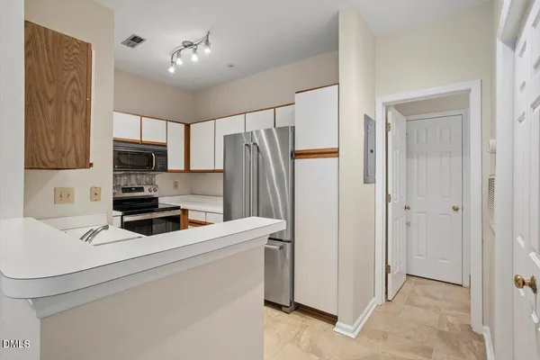 a kitchen with stainless steel appliances a refrigerator sink and white cabinets