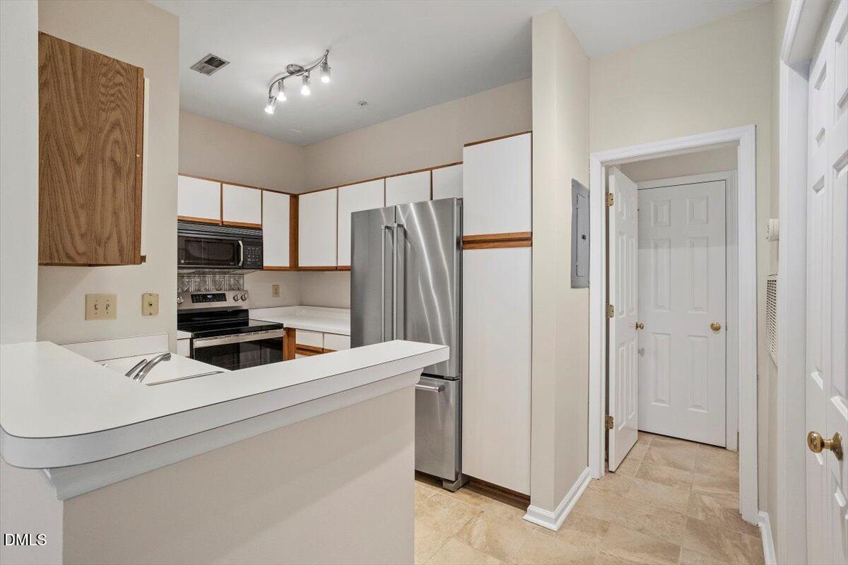 1001 Brighthurst Drive, Unit 106 Raleigh, NC 27605 - Photo 18 of 23 a kitchen with stainless steel appliances a refrigerator sink and white cabinets