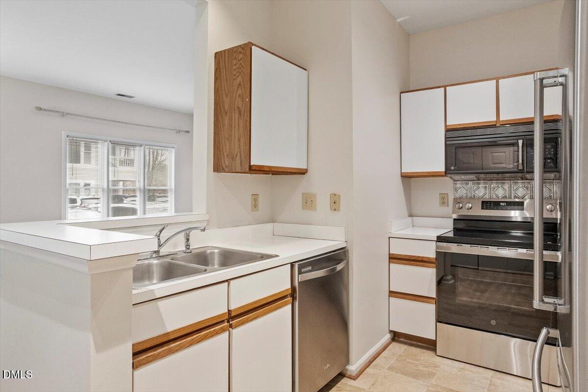 1001 Brighthurst Drive, Unit 106 Raleigh, NC 27605 - Photo 19 of 23 a kitchen that has a sink and a stove top oven