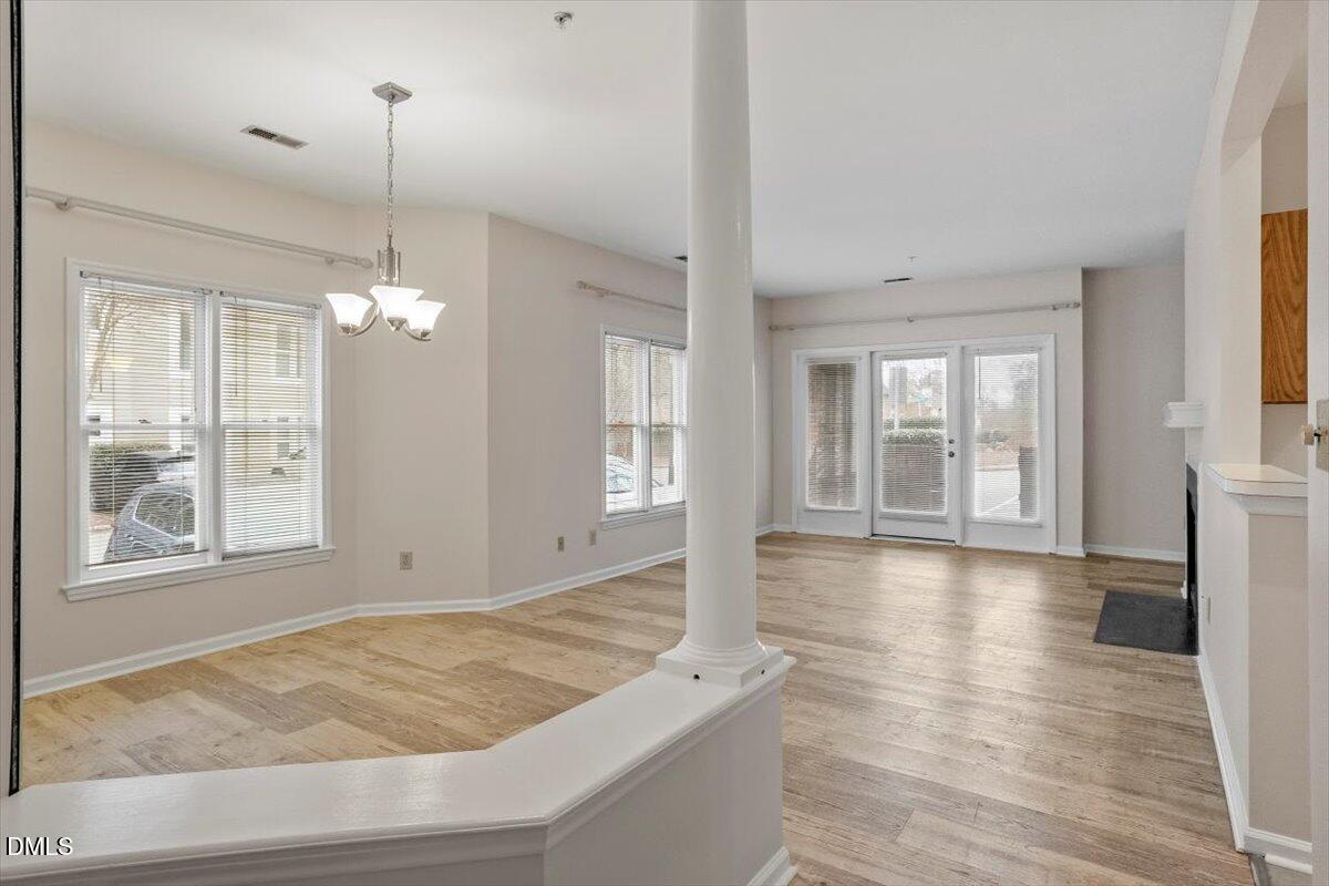 1001 Brighthurst Drive, Unit 106 Raleigh, NC 27605 - Photo 6 of 23 a view of an empty room with wooden floor and a window