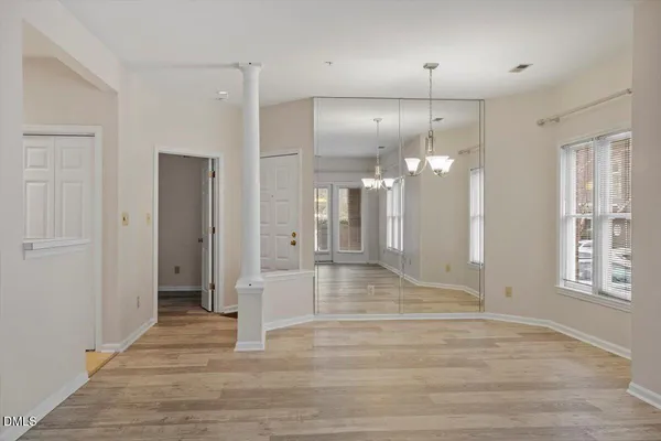 a view of a hallway with wooden floor and a bathroom