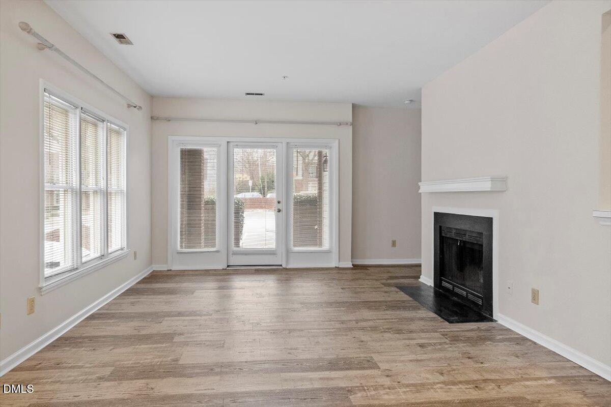 1001 Brighthurst Drive, Unit 106 Raleigh, NC 27605 - Photo 10 of 23 a view of an empty room with wooden floor and a window