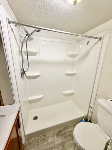 7 Foothill Boulevard Pocatello, ID 83204 - Photo 4 of 13 White shower stall with integrated shelving, handheld shower fixture, and a chrome shower rod